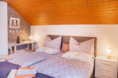 a bedroom with a bed with pink and white pillows at Haus Christina in Seeboden