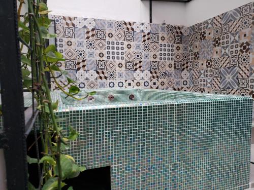 y baño con bañera y pared de azulejos. en Aima Ibagué en Ibagué