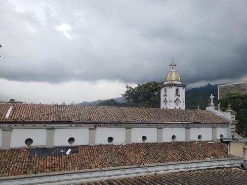 a white building with a clock tower on top of a roof at Aima Ibagué in Ibagué