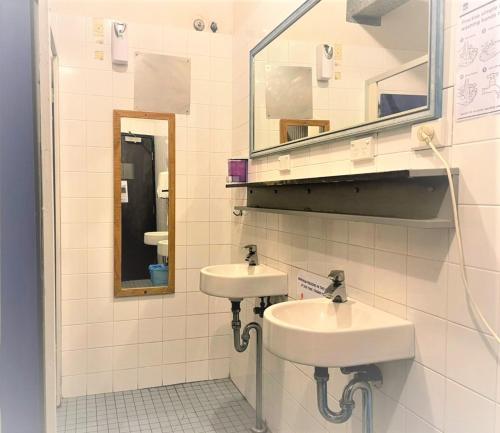 Baño con 2 lavabos y espejo en Boardrider Backpackers and Budget Motel, en Sídney