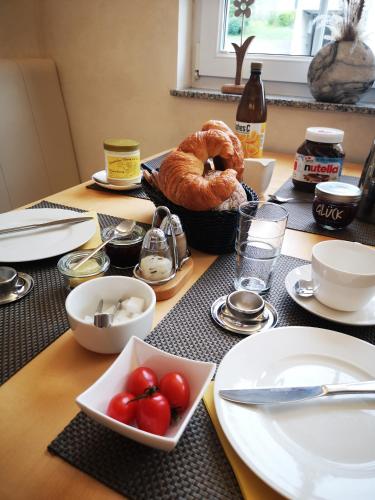 a table with plates and bowls of tomatoes and bread at Haus Marvin in Döttingen