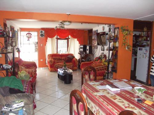 una sala de estar con paredes y sillas de color naranja y una mesa. en La Cabaña en Huaraz