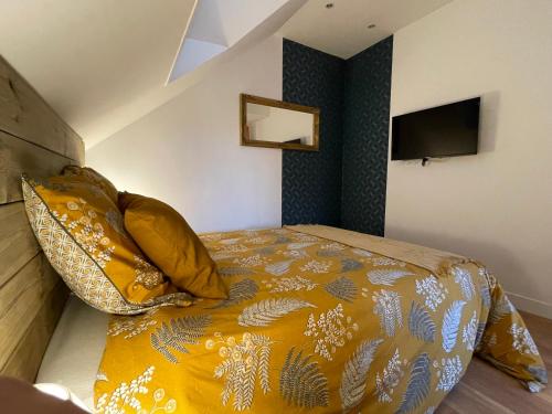 a bedroom with a bed with a yellow comforter at Gîte au pied du château de Chaumont-Sur-Loire, Chambord et Amboise in Onzain