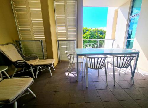 a blue table and chairs in a room with a balcony at The Beach Cabarita in Cabarita Beach