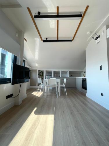 a living room with a table and chairs and a television at Agora LX Studios & Suites in Thessaloniki