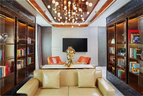 a living room with a couch and bookshelves at Park Plaza Beijing Science Park in Beijing