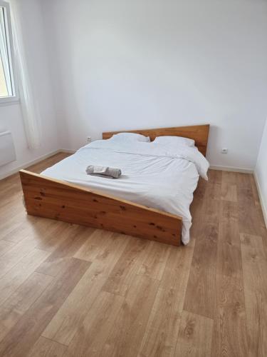 uma cama com uma estrutura de madeira num quarto em Villa 2 luxe em Fresney-le-Vieux