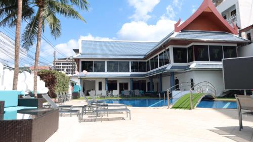 a house with a swimming pool next to a resort at The Yorkshire Hotel - SHA Certified in Patong Beach