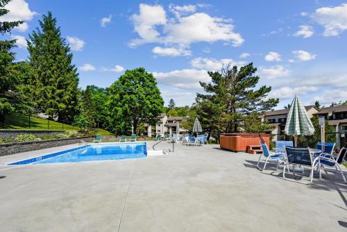 un patio con sillas y una piscina en Pinnacle E26, en Killington