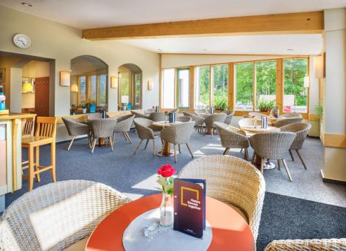 a restaurant with tables and chairs and windows at JUFA Hotel Altaussee in Altaussee