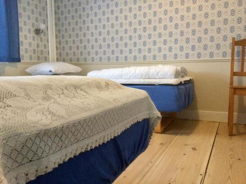 two beds in a bedroom with blue and white wallpaper at STF Vandrarhem Edsbyn in Edsbyn
