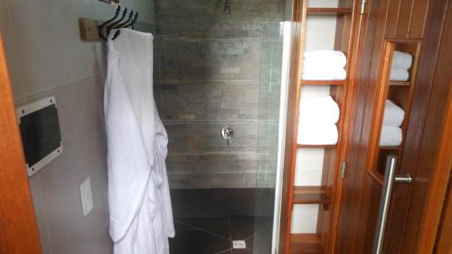 a bathroom with a shower with a white shirt on at Calas del Diablo in Punta Del Diablo