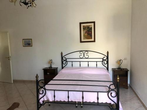 a bedroom with a black bed with a pink blanket at Casa Lionetto in Salve