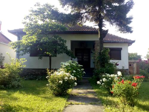 a small white house with a tree in the yard at Apartman Otvoreno polje in Arandelovac