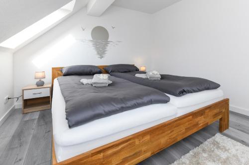 a bedroom with a large bed with black and white pillows at Ferienwohnung Abendrot im Haus Auszeit Crusoh in Schweindorf