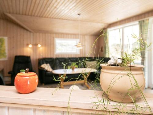 ブラーバンドにある8 person holiday home in Bl vandのリビングルーム(鉢植えの植物2本が置かれたテーブル付)