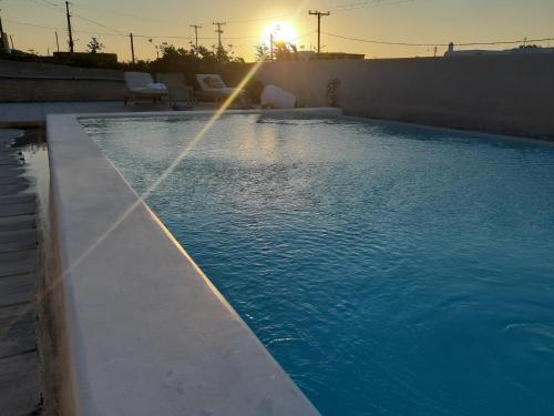 a swimming pool with a water fountain in the sunset at Ftelia Breeze in Klouvas