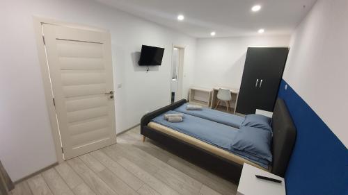 a bedroom with a blue bed and a tv at Marcos Apartments Victoriei - self check-in in Reşiţa