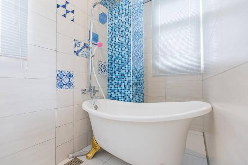 y baño blanco con bañera y ducha. en Footprint Garden B&B, en Dongshan