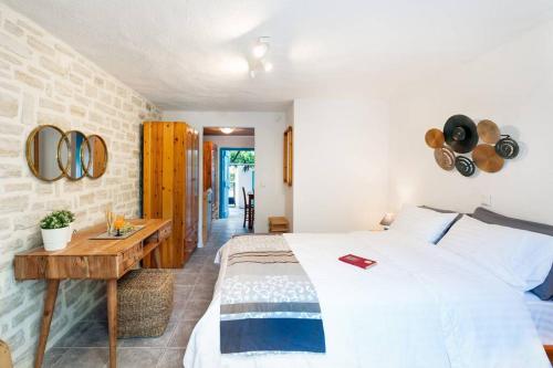 ein Schlafzimmer mit einem großen Bett und einem Holztisch in der Unterkunft A 3bedroom country house, with pool close to beach in Roumelí