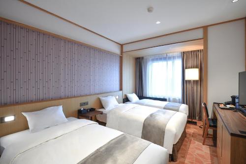 a hotel room with two beds and a television at Hotel Gracery Taipei in Taipei
