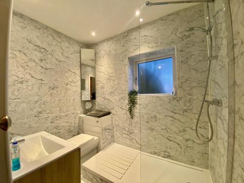 a bathroom with a shower and a sink at Clover Cottage in Beeley