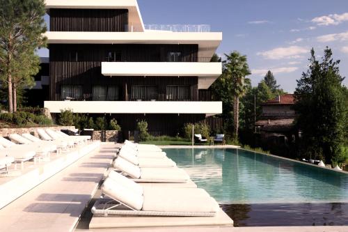 a building with a swimming pool and lounge chairs at Laqua by the lake in Pettenasco