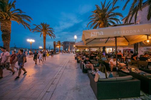 a crowd of people walking on a street at night at Hotel Concordia in Trogir