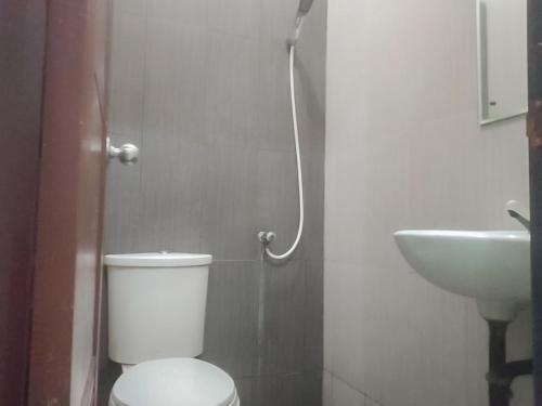 een badkamer met een toilet en een wastafel bij Colombus Residence Karawang Mitra RedDoorz in Telukjambe