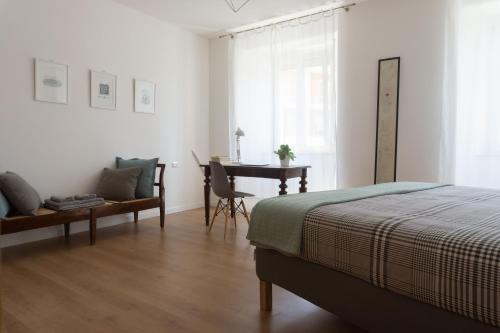 een slaapkamer met een bed, een bureau en een tafel bij Appartamento Camillo in Macerata