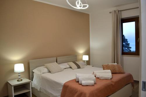 a bedroom with a bed with white sheets and a window at B&B Trepo Santa Domenica in Santa Domenica