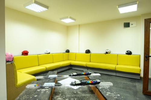a yellow couch in a room with tools on the floor at Parklands Hotel & Pool in Bansko