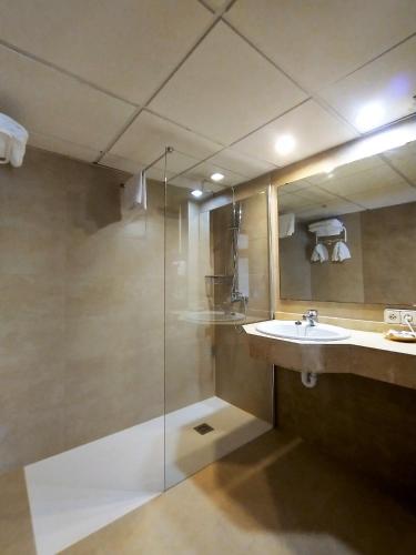 a bathroom with a glass shower and a sink at Hotel Marina Playa De Palma in El Arenal