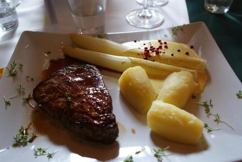 a plate of steak and potatoes on a table at Hotel - Restaurant - Sonnblick in Heiligenblut