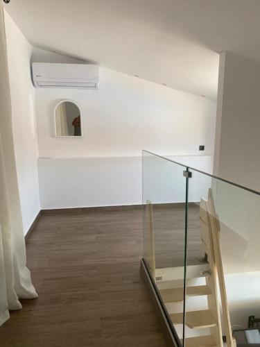 a glass staircase in a white room with a window at Perland Vacation in Sidari