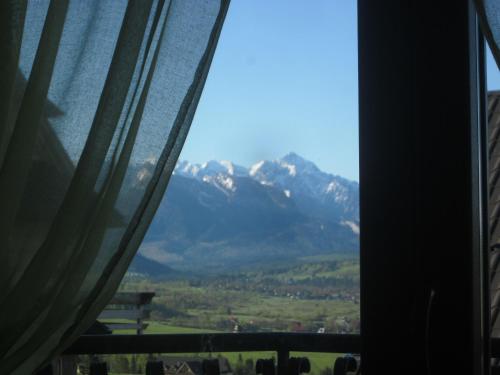 a view of a mountain range from a window at Apartamenty i pokoje rodzinne in Czarna Góra