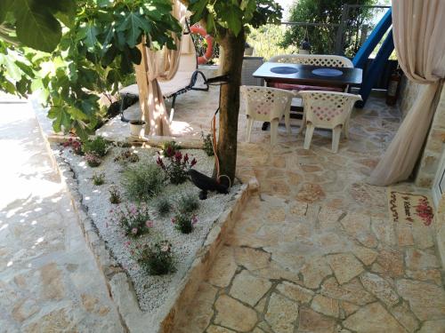 a patio with a table and chairs and a tree at STUDIO Carpe Diem in Utjeha