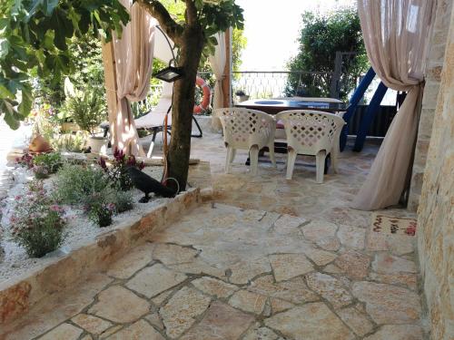 a patio with a table and chairs and a tree at STUDIO Carpe Diem in Utjeha