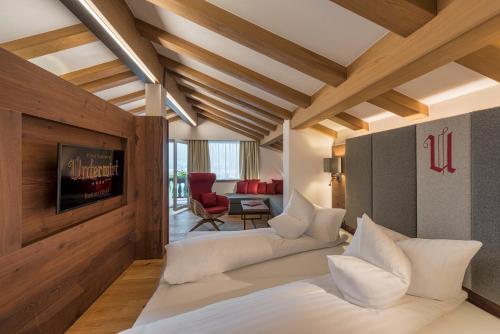 a hotel room with a bed and a living room at Hotel Unterwirt in Reit im Winkl