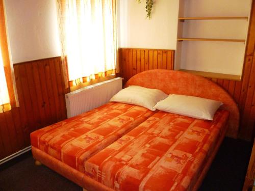 ロキトニツェ・ナト・イゼロウにあるPenzion Pod Studenovemのベッドルーム1室(大きなオレンジ色のベッド1台、枕2つ付)