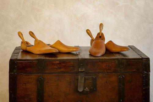 four pairs of shoes sitting on top of a trunk at Domus Calzolari in Gubbio