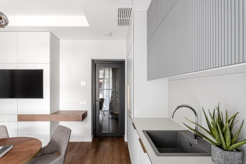 a kitchen with white walls and a sink and a table at Luxurious Apartment in Vilnius Old Town by Reside Baltic in Vilnius