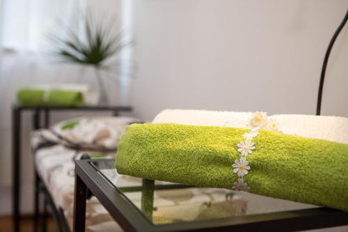 a green towel sitting on top of a glass table at Apartment Doris in Opatija