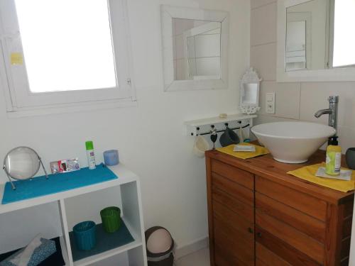 une salle de bain avec un lavabo blanc et une commode en bois dans l'établissement Notre campagne provençale, à Avignon