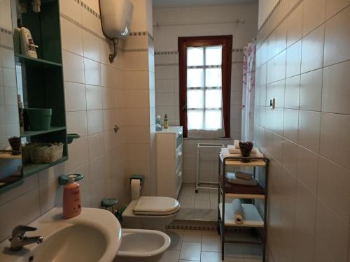 baño con lavabo y aseo y ventana en Casa di Zoe apartment - Punto di sosta x bikes auto e moto a 20 minuti dall'autostrada - parcheggio privato - giardino con barbecue -, en Civita Castellana