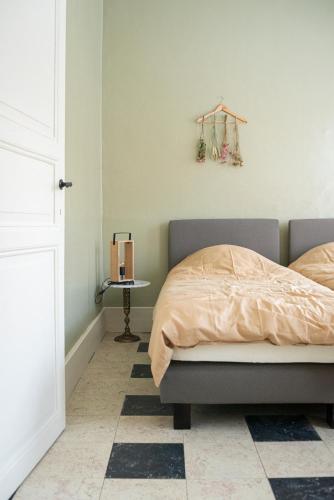 a bedroom with a bed and a side table at Avant Garde in Watou