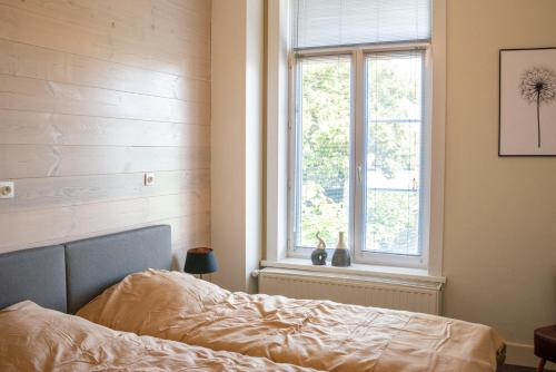 a bedroom with a bed and a window at Avant Garde in Watou