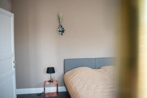 a bedroom with a bed and a lamp on a wall at Avant Garde in Watou