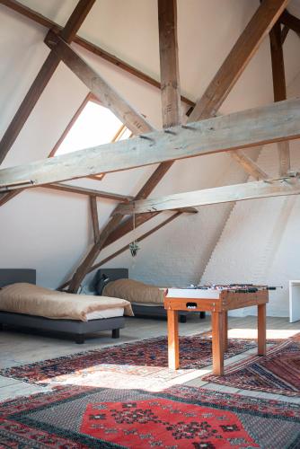 a room with a table and a rug in a attic at Avant Garde in Watou