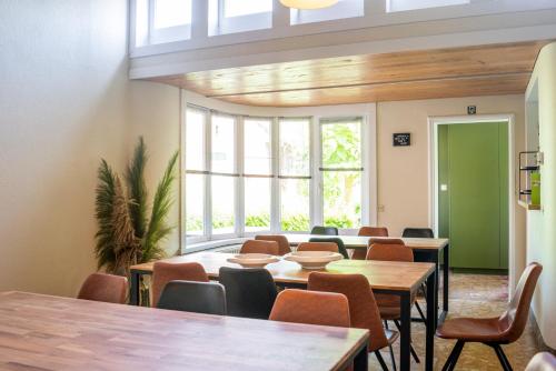 a room with tables and chairs and a large window at Avant Garde in Watou